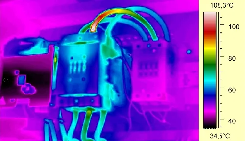 Motorkontaktor hőképe szivárványpalettával: a hibás kábelcsatlakozás és a kábelív piros-fehéren világít, a környező vezetők 35–60 °C körüliek; a skála 34,5–108,3 °C