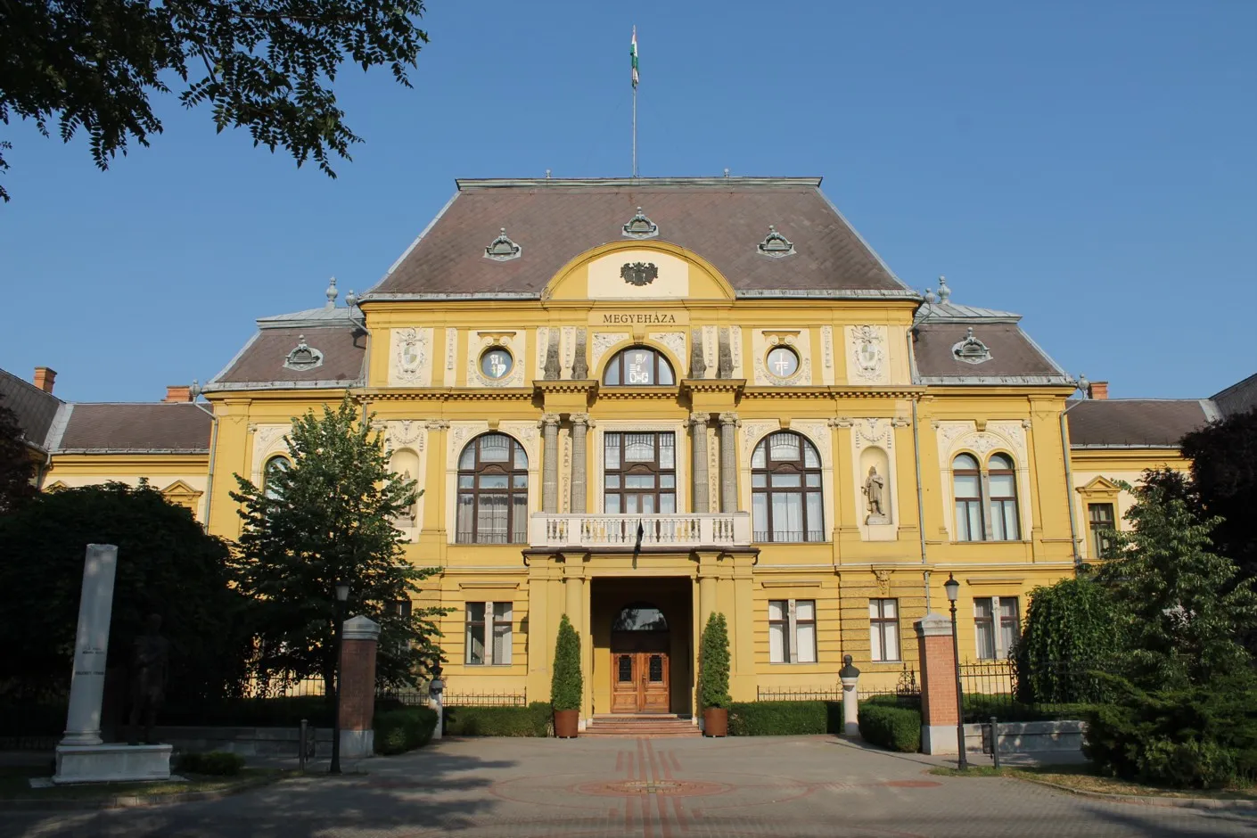 A nyíregyházi megyeháza sárga, historizáló homlokzata kék ég alatt
